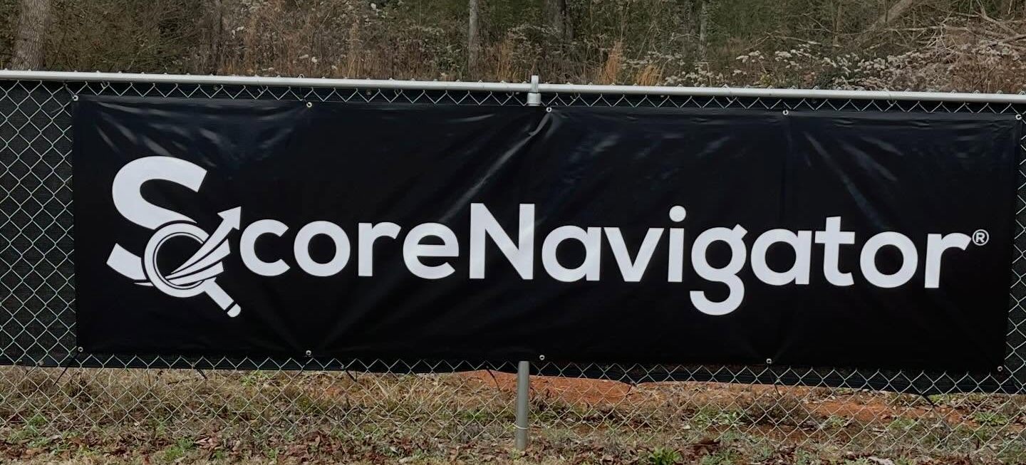 A sponsor banner on the outfield fence at Factory Field